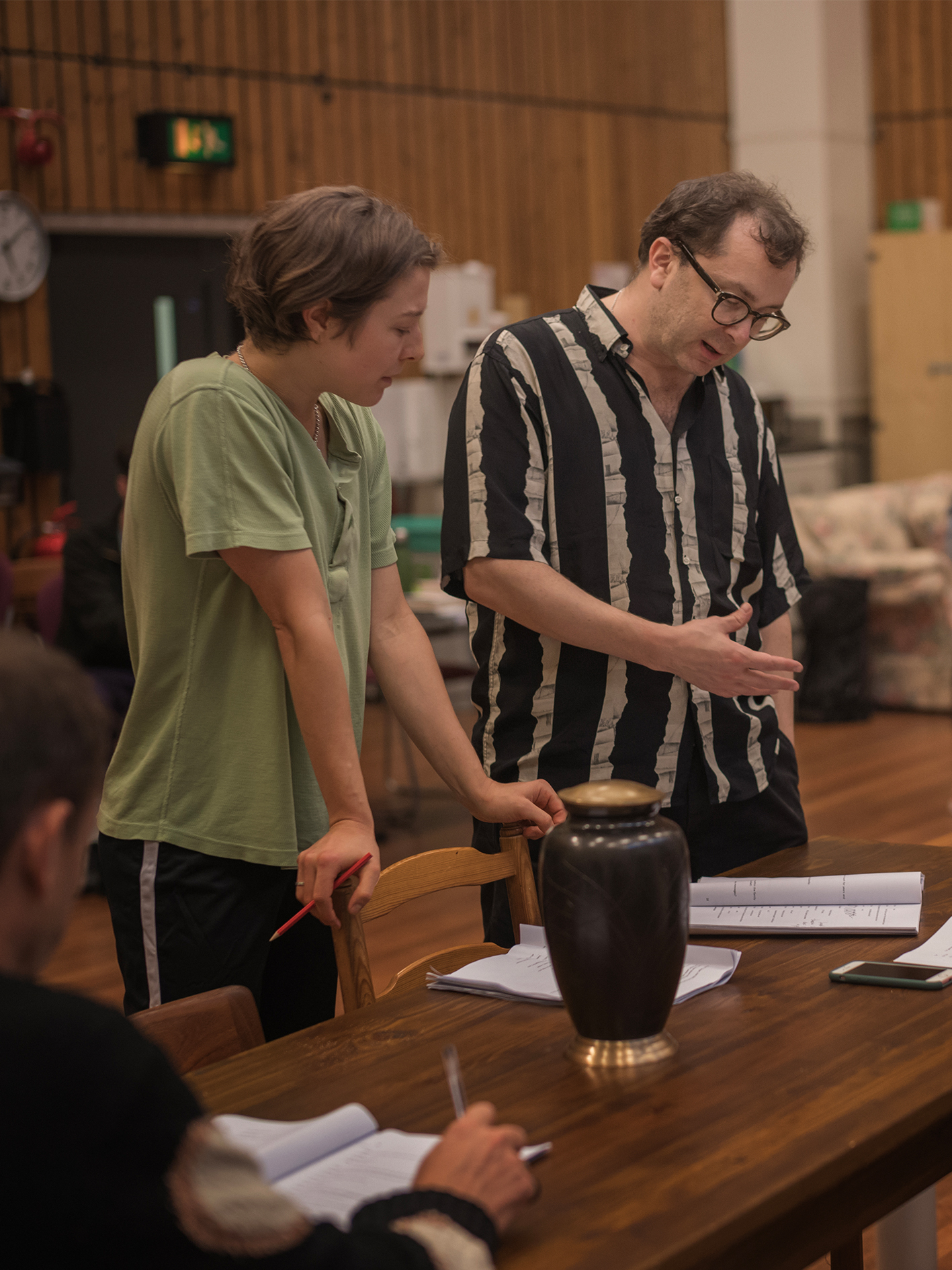 A photo from rehearsals for The Other Place, showing Emma D'Arcy (Annie) and Alexander Zeldin (director) examining a script.