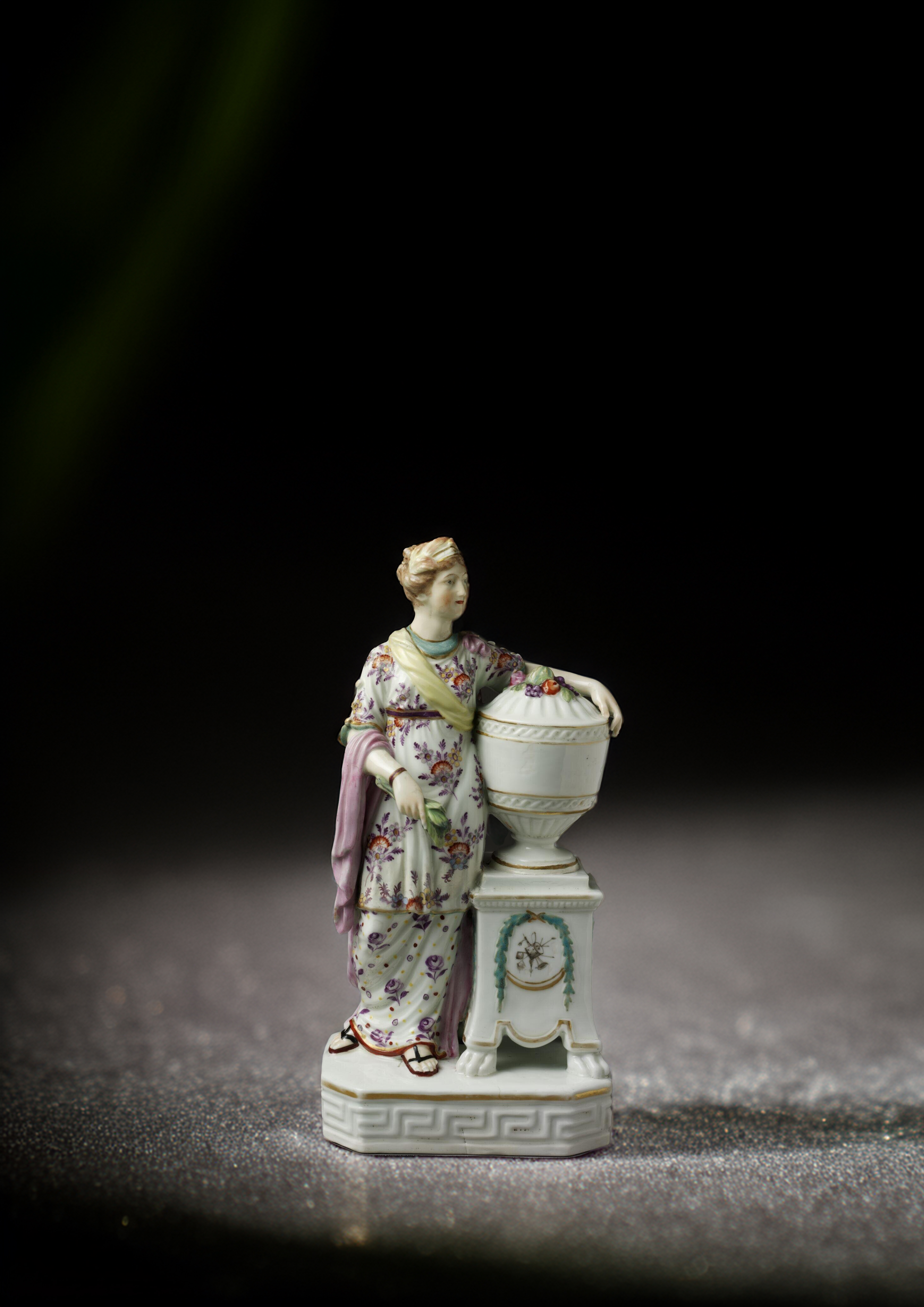 Image of a porcelain statuette depicting a woman holding an urn